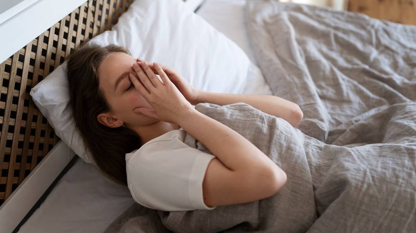 high-angle-anxious-woman-laying-bed_23-2149450353