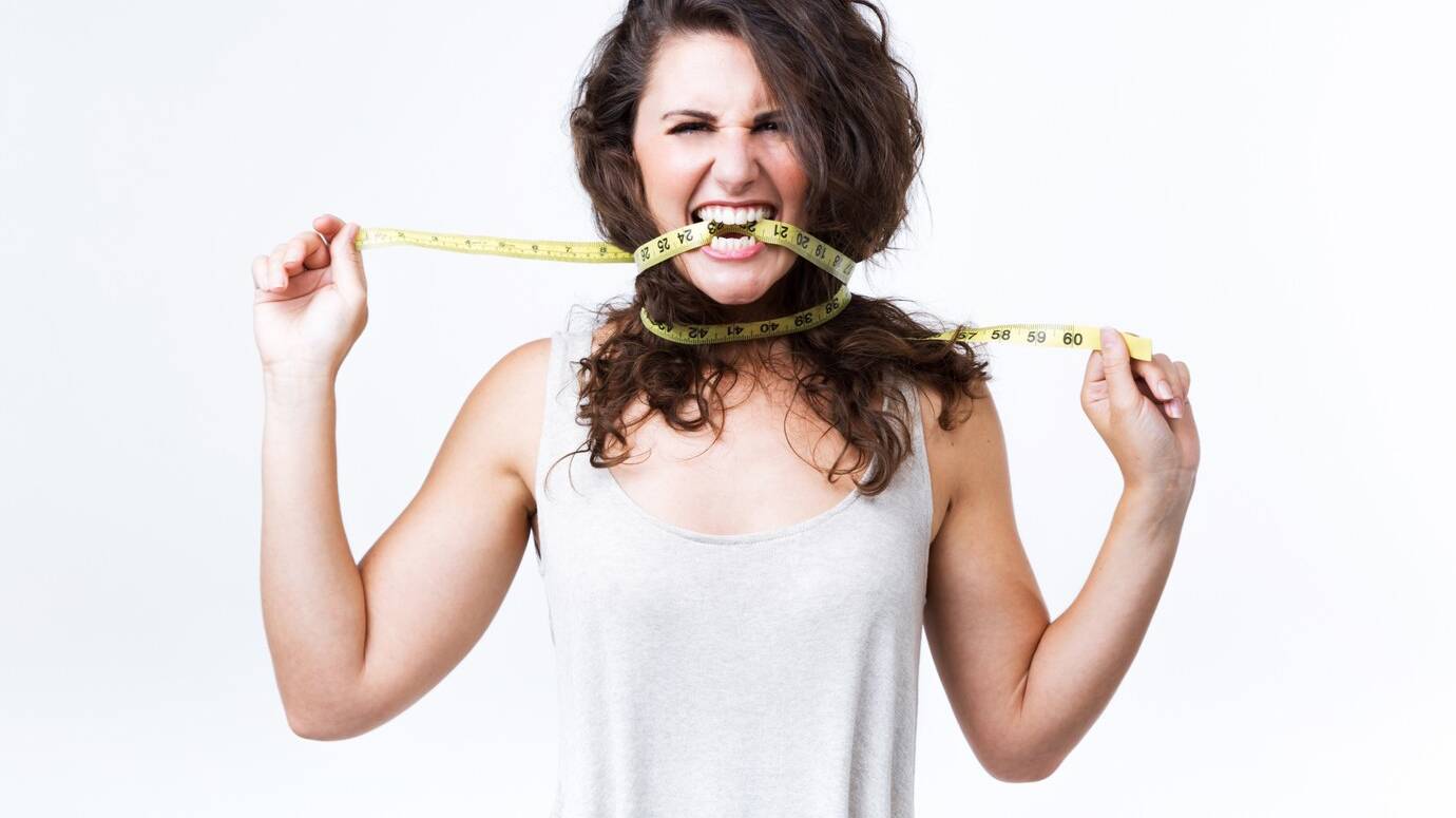 young-woman-biting-tape-measure-white-background_1301-7244