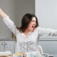 portrait-young-woman-sitting-breakfast-table-stretching-her-arms_23-2148161222