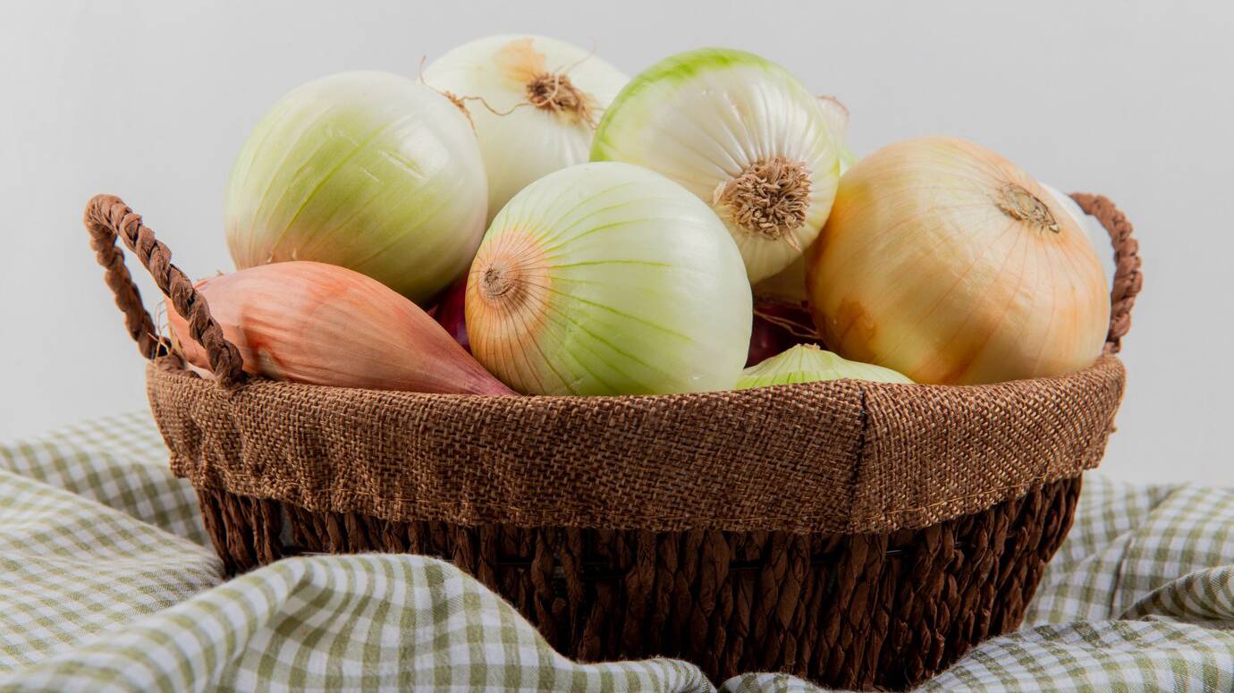 side-view-onions-basket-plaid-cloth-white-background_141793-9453