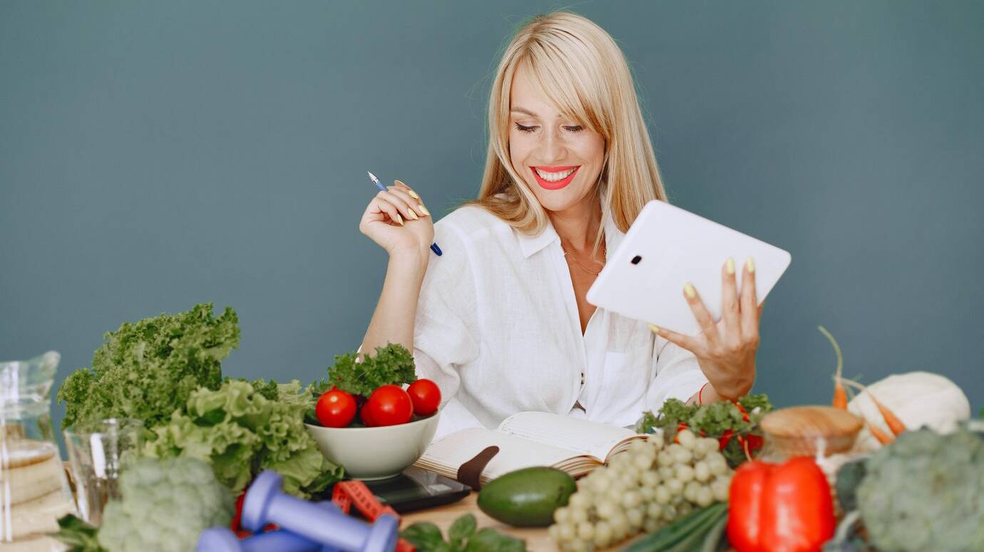 beautiful-girl-make-salad-sporty-blonde-kitchen-woman-writing-recipe-notebook_1157-41841