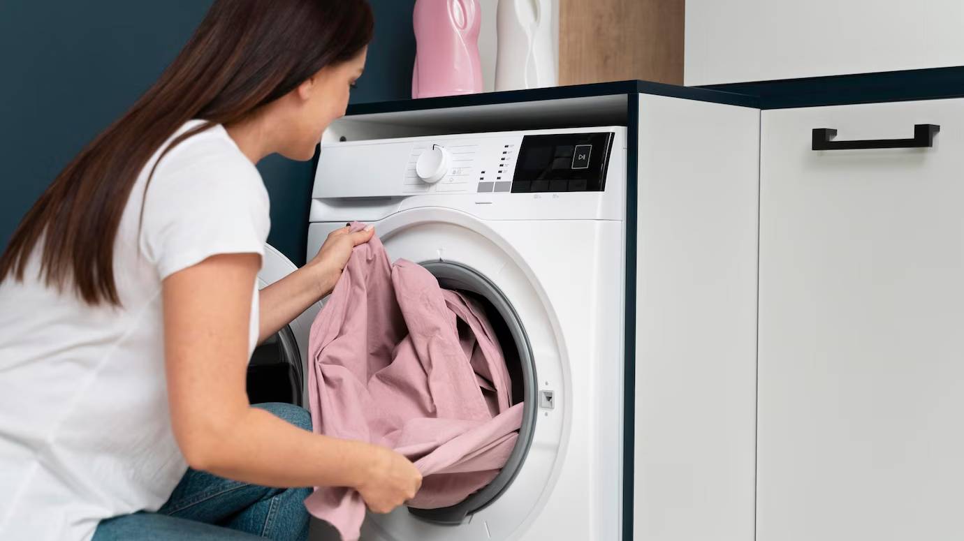 woman-taking-clothes-from-washing-machine_23-2149117037