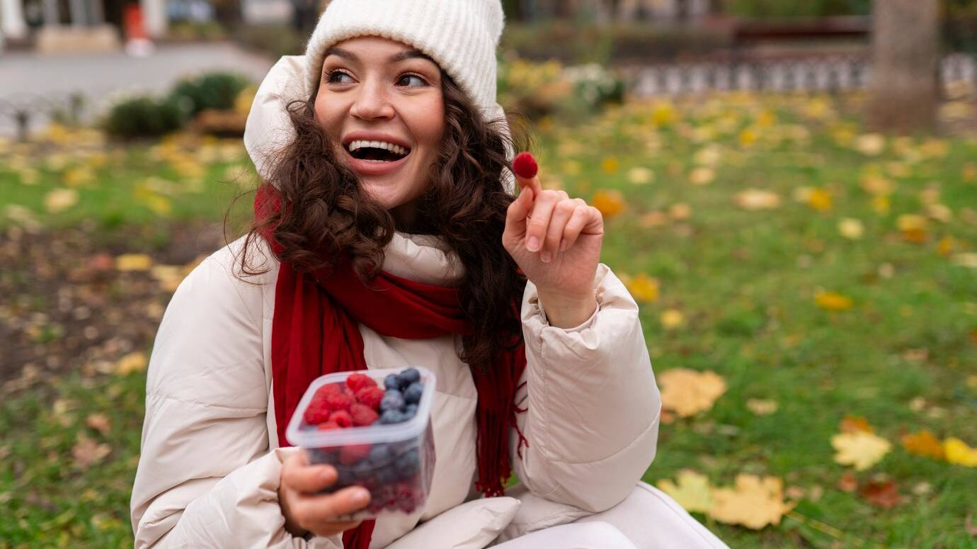 front-view-woman-eating-berries_23-2150062951