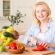 portrait-senior-woman-cutting-red-bell-pepper-with-knife-chopping-board-kitchen_23-2148128002