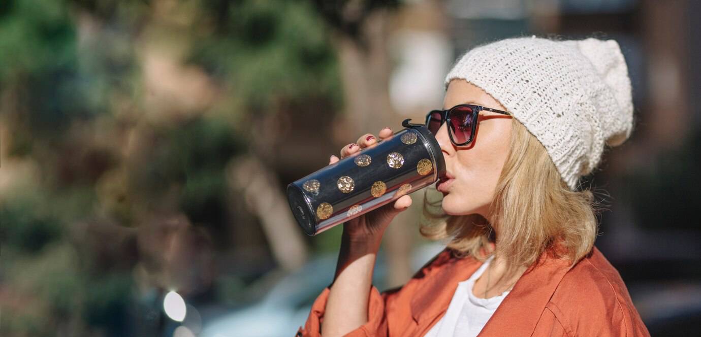 pretty-woman-enjoying-beverage-street_23-2147765445