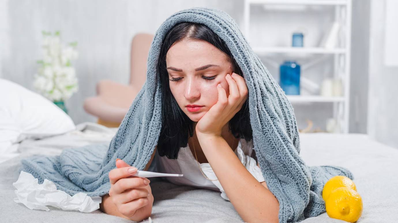 young-woman-with-scarf-around-her-head-checking-fever-with-thermometer_23-2147948552