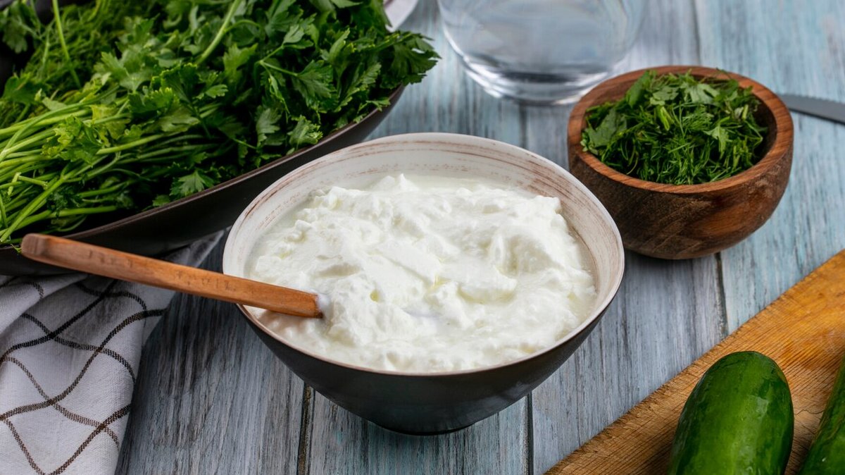 front-view-cucumbers-board-with-yogurt-greens-gray-surface_141793-17671