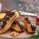 front-view-cup-tea-with-delicious-choco-eclairs-dark-background_140725-91632