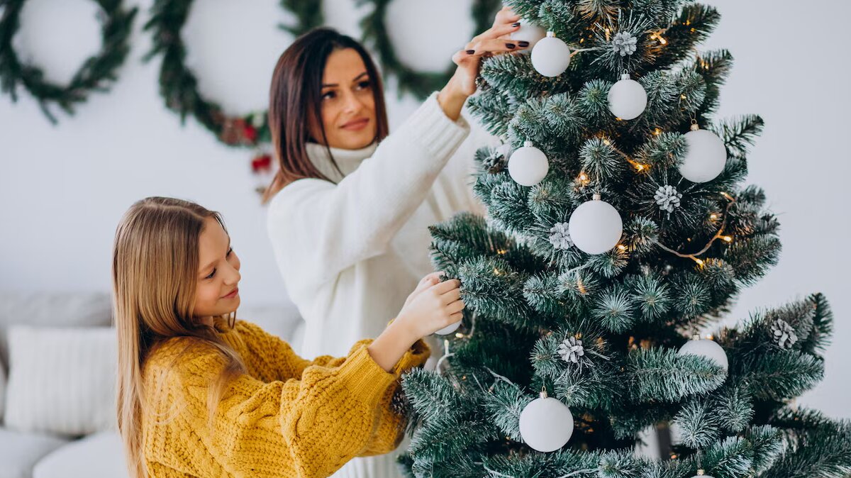 mother-with-daughter-decorating-christmas-tree_1303-25465