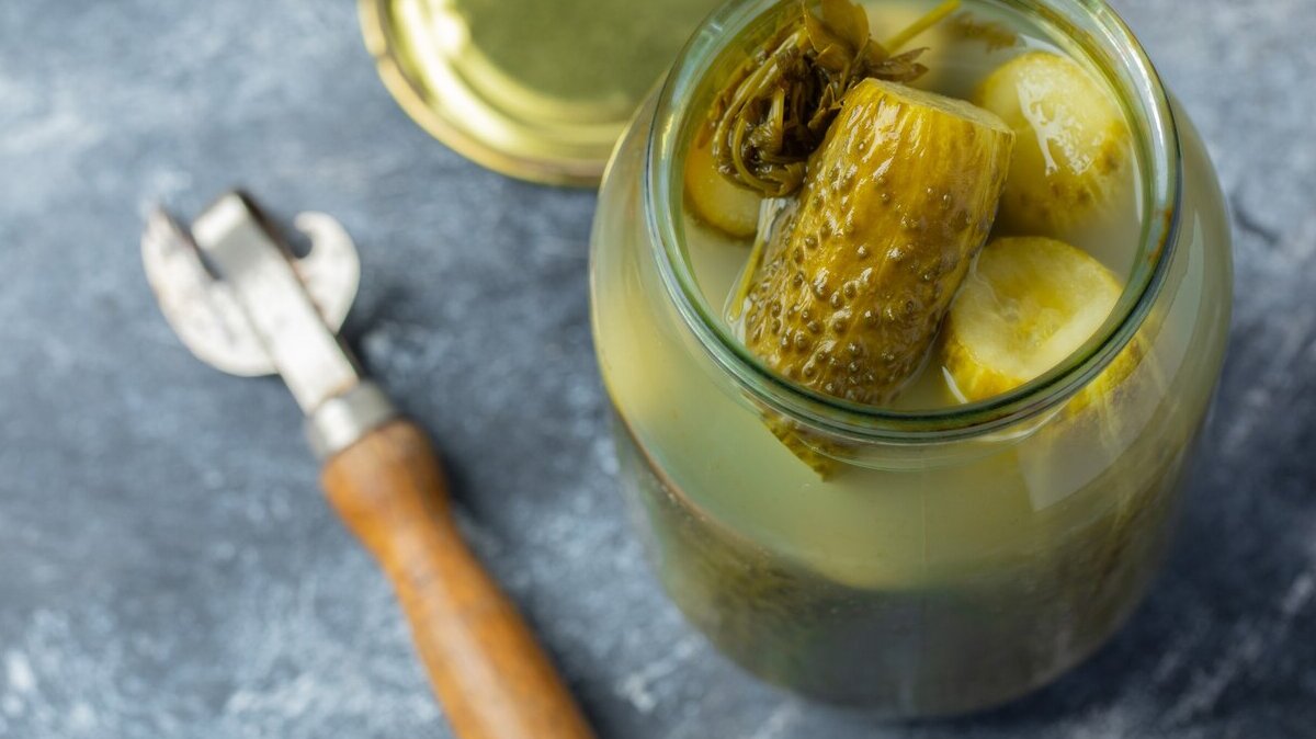 opened-jar-full-with-pickled-cucumber-grey-background_114579-65628