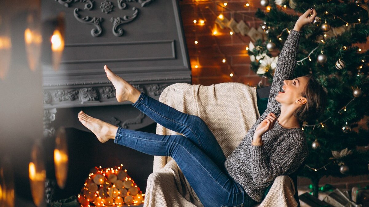 woman-sitting-chair-by-christmas-tree_1303-12415