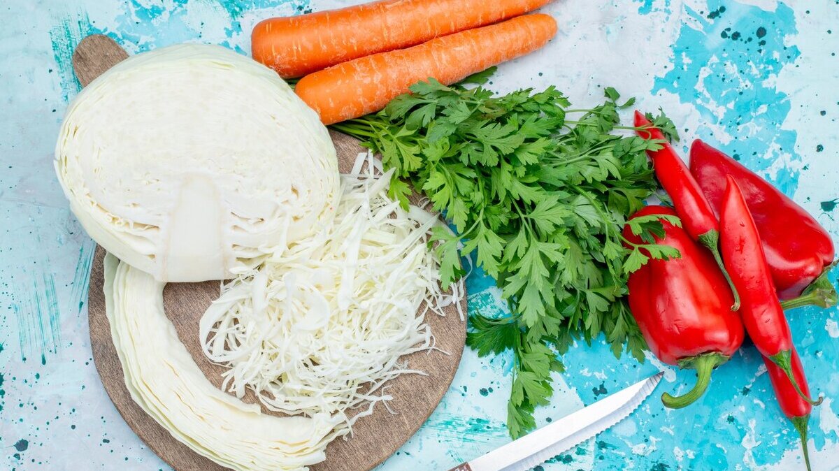 top-view-fresh-vegetables-greens-sliced-cabbage-carrots-spicy-hot-peppers-bright-blue-food-meal-vegetable-lunch-healthy-salad_140725-34465